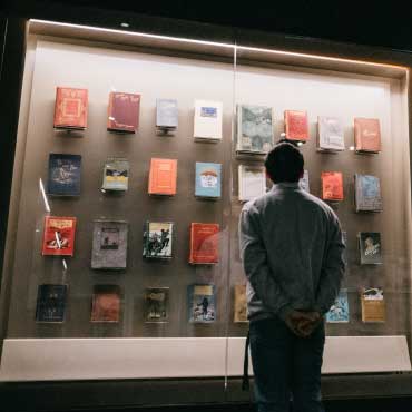 Person looking at a museum display of books