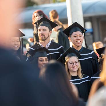 A small group of graduates standing in their regalia