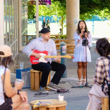 Two musicians playing music and singing for a crowd.