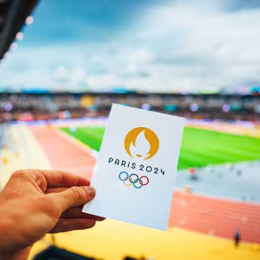 Person holding booklet with 2024 Olympics logo