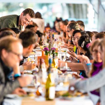 People enjoying a long table dinner at UBC's Harvest Feastival