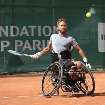 Dr. Rob Shaw playing tennis in wheelchair