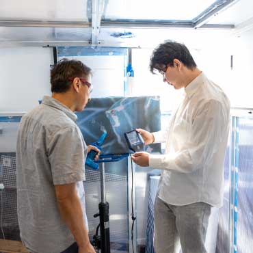 Dr. Sunny Li and graduate student Xudong Wang examine airflow through an ART device located in a sealed enclosed chamber