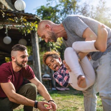 Same-sex couple playing with child