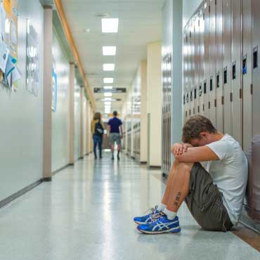 Youth sitting in the hallway of a school