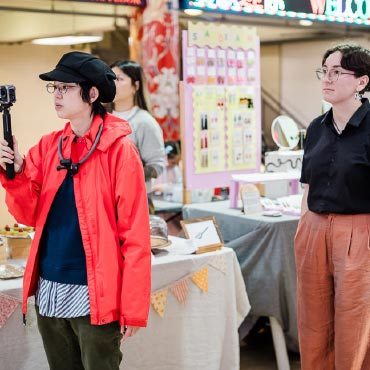 Two people looking in the same direction by event booths