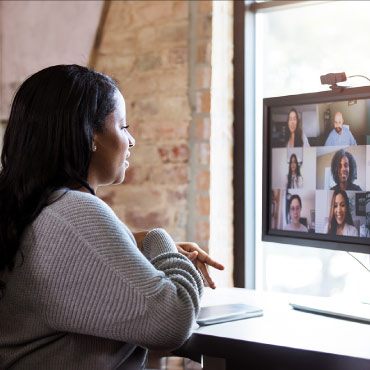 Person sitting in front of a computer monitor doing a video call with other people