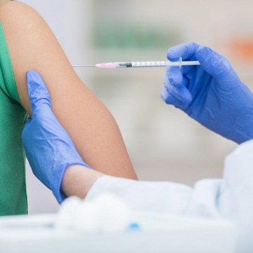 Person getting a vaccine by a healthcare worker