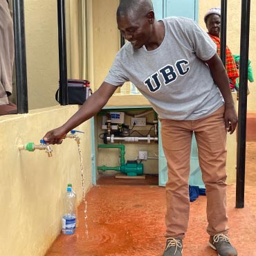 " UBC researchers Dr. Sara Beck and Dr. Paul Onkundi Nyangaresi join students and staff of Rianyabayo Memorial Academy."