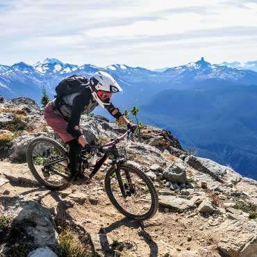 A mountain biker skillfully navigates a rocky trail