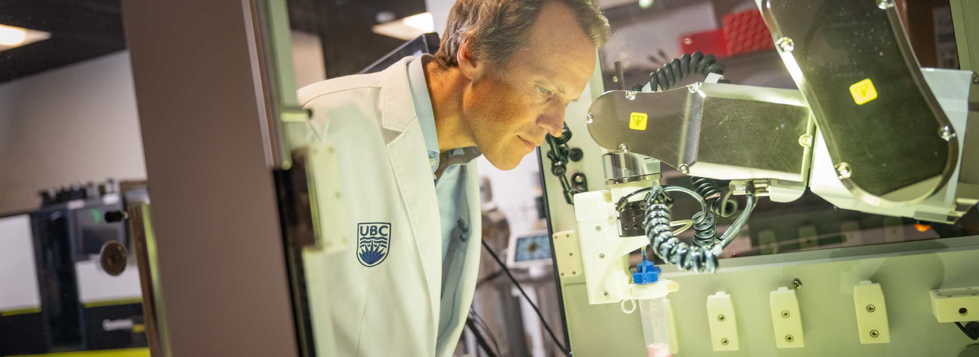 Dr. Haakon Nygaard peers inside the 3D bioprinter at the Djavad Mowafaghian Centre for Brain Health