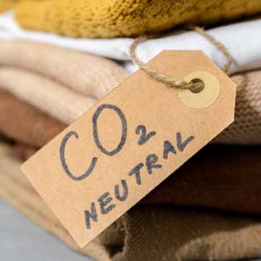 A pile of folded clothing with a tag labelled as CO2 neutral