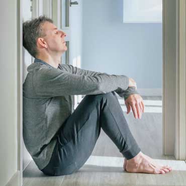 Person sitting in the hallway looking stressed